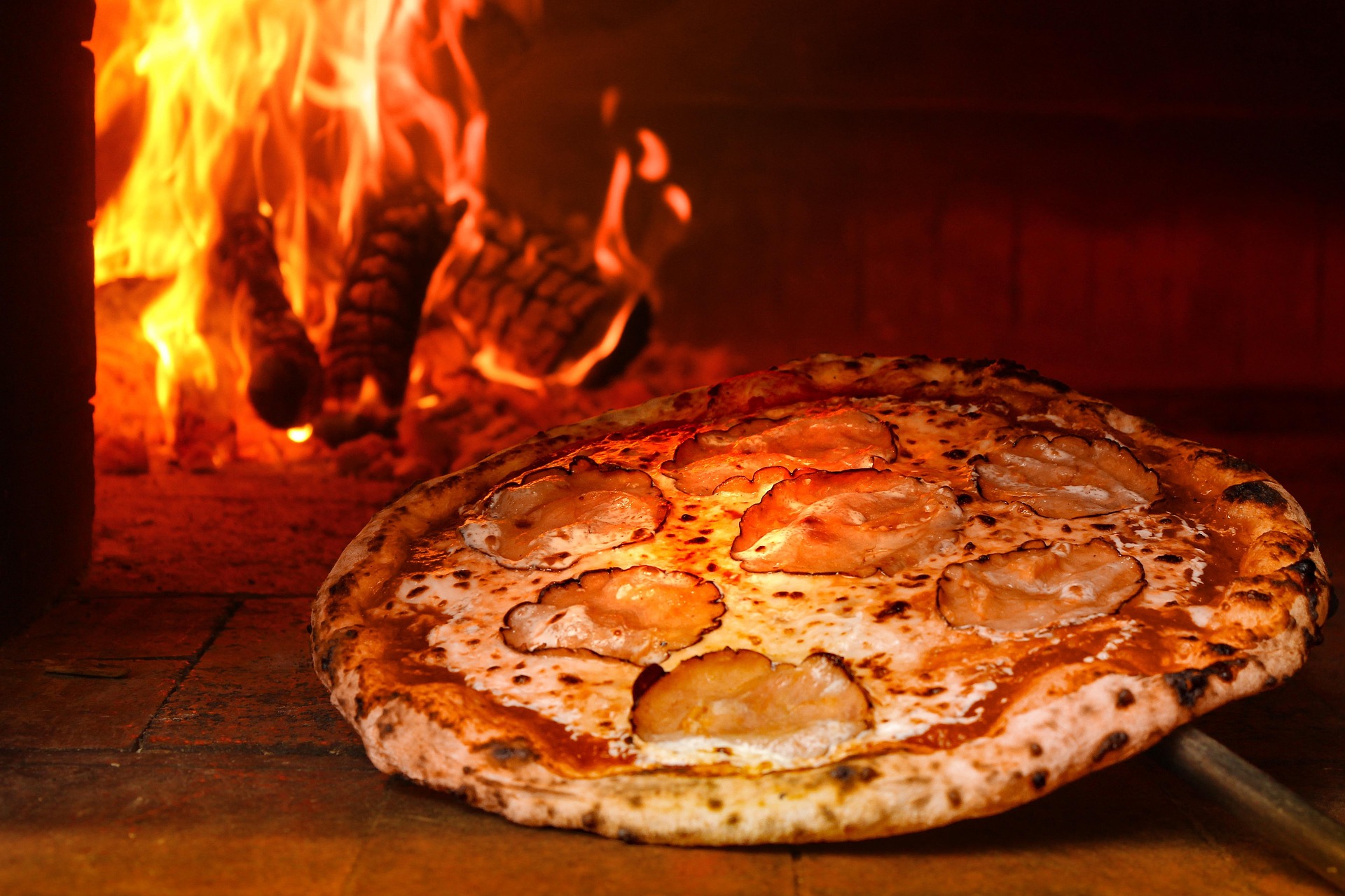 Forno a legna acceso, pizza in cottura